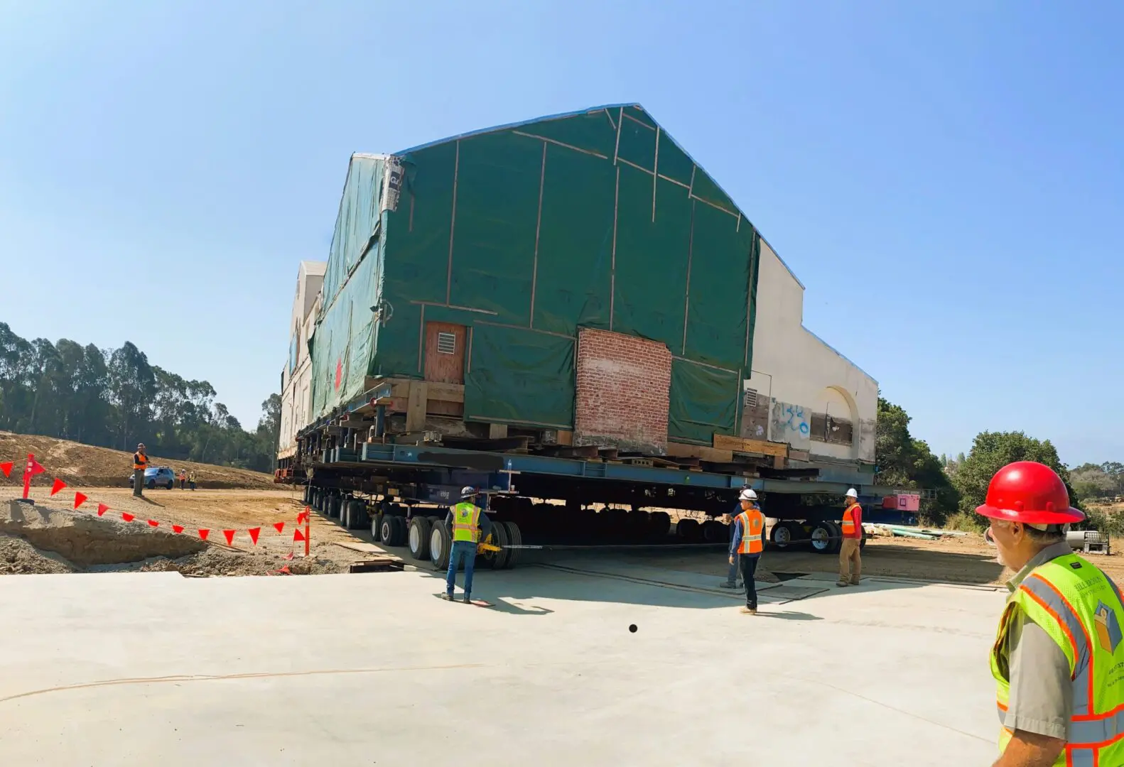 Construction crew moving a large building